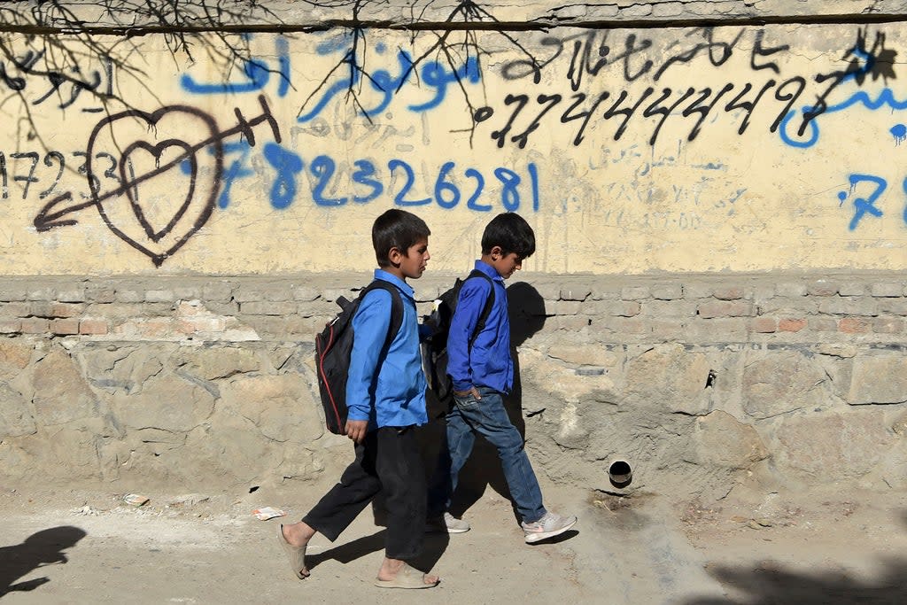 Children walk home after attending school along a roadside in Kabul, October 2021  (AFP/Getty)