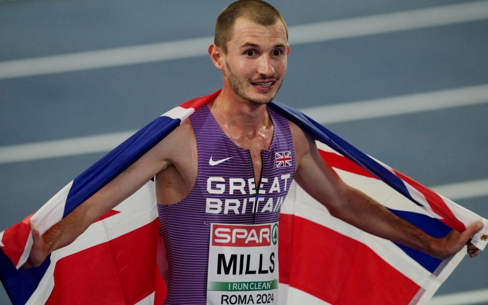 Britain's George Mills celebrates with his national flag after finishing second in the men's 5000m