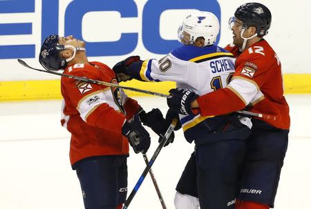 Oct 12, 2017; Sunrise, FL, USA; St. Louis Blues center Brayden Schenn (10) battles with center Micheal Haley (18) as Florida Panthers defenseman Ian McCoshen (12) holds him back in the third period at BB&T Center. Robert Mayer-USA TODAY Sports