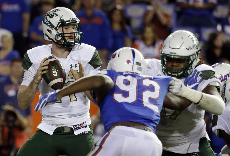 UAB quarterback A.J. Erdely, left, looks for a receiver as he is pressured by Florida defensive lineman Jabari Zuniga (92) during the second half of an NCAA college football game, Saturday, Nov. 18, 2017, in Gainesville, Fla. (AP Photo/John Raoux)