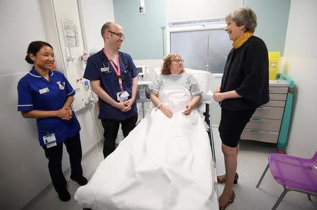 Britain's Prime Minister Theresa May speaks to patient Sandra Dunn as she visits Frimley Park Hospital near Camberley, Britain, January 4, 2018. REUTERS/Toby Melville