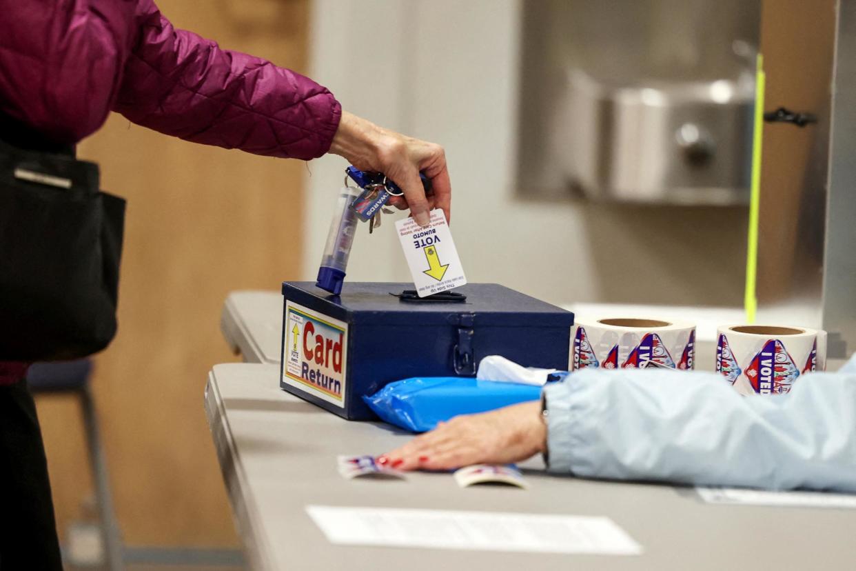 <span>A voter turns in a card used to cast a ballot in Boulder City, Nevada, on Tuesday.</span><span>Photograph: Ronda Churchill/Reuters</span>