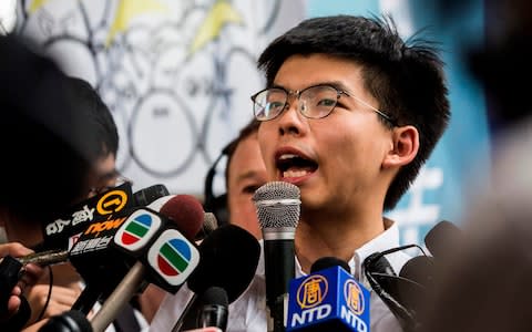 Hong Kong democracy activist Joshua Wong speaks to the media after leaving Lai Chi Kok Correctional Institute in Hong Kong  - Credit: AFP
