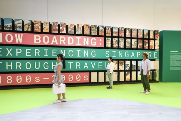 Now Boarding: Experiencing Singapore through Travel, 1800s – 2000s exhibition with man and women viewing it