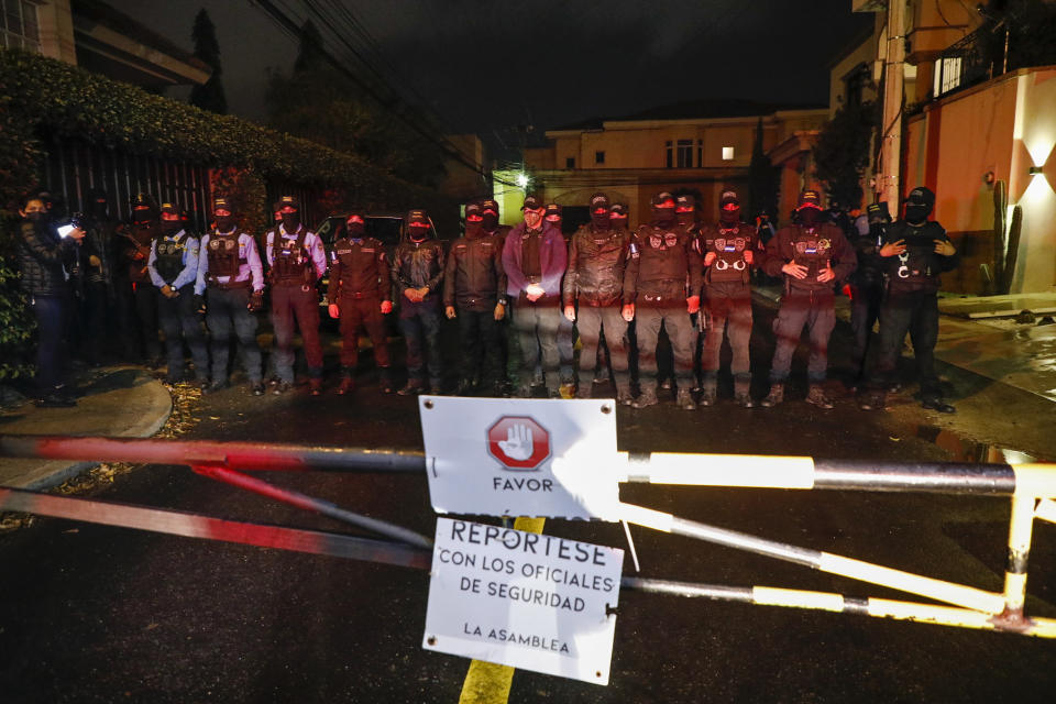 Special Forces Police block a street near the house of former Honduran President Juan Orlando Hernandez, behind a residential sign that reads in Spanish "Please, check in with security," in Tegucigalpa, Honduras, late Monday, Feb. 14, 2022. After years of speculation in Honduras, the United States formally requested the arrest and extradition of Hernández less than three weeks after he left office. (AP Photo/Elmer Martinez)