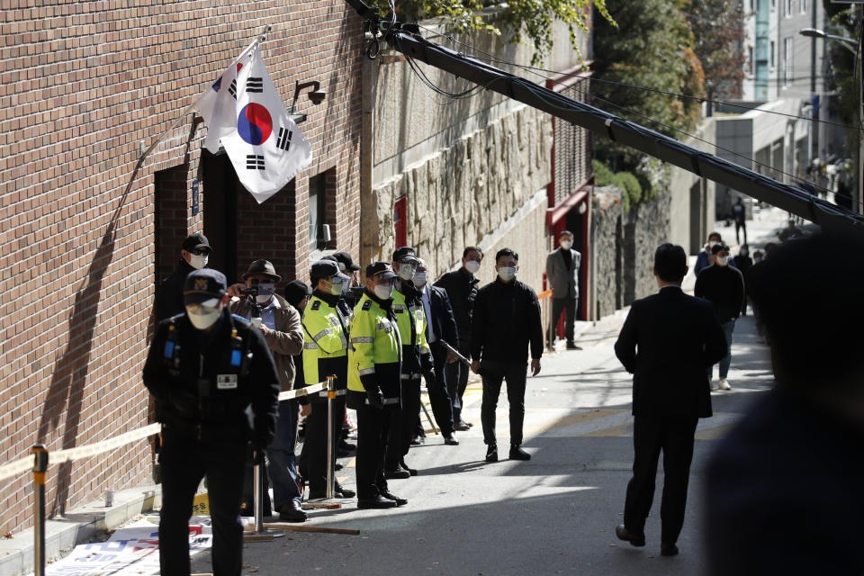 South Korean police officers stand outside a residence of former President Lee Myung-bak in Seoul, South Korea, Monday, Nov. 2, 2020. Lee was sent back to prison on Monday, four days after the country’s top court upheld a 17-year prison term on him over corruption crimes. (AP Photo/Lee Jin-man)