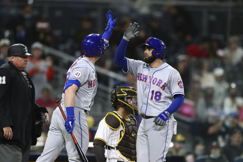 New York Mets' Jose Peraza (18) is congratulated by Billy McKinney, left, after hitting a solo home run in the fifth inning of the team's baseball game against the San Diego Padres on Saturday, June 5, 2021, in San Diego. (AP Photo/Derrick Tuskan)