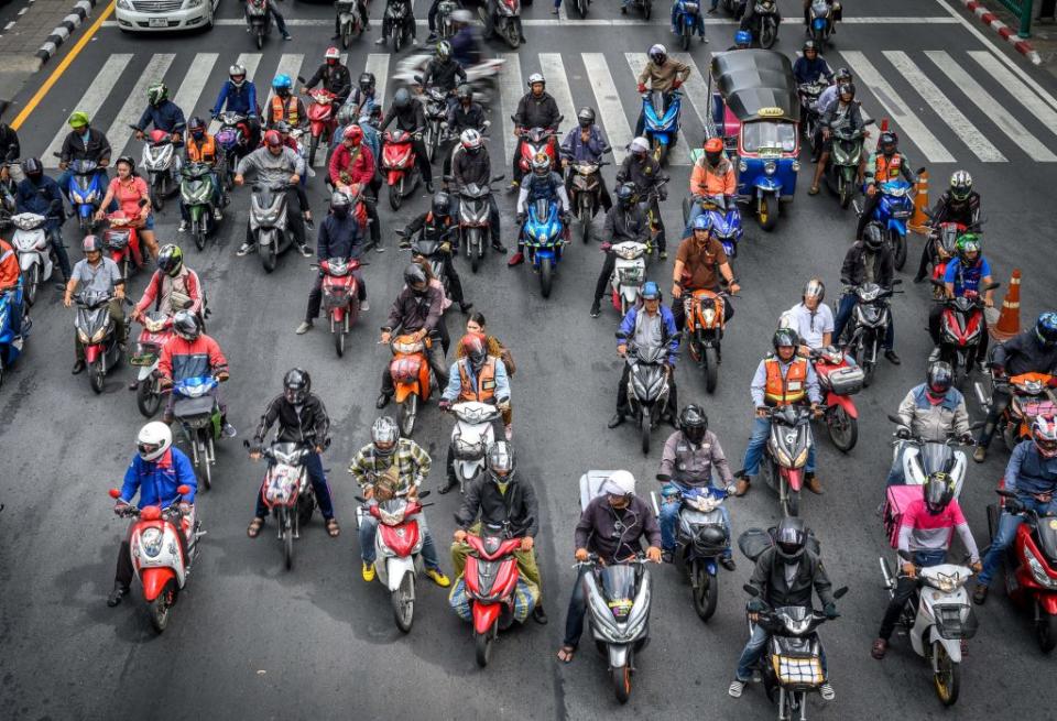 Dozens of motorcyclists wait at a Bangkok junction.