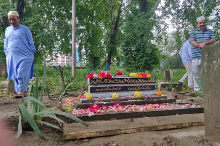 People leave after offering prayers at the grave of Mohammad Sikander Bhat, in Srinagar