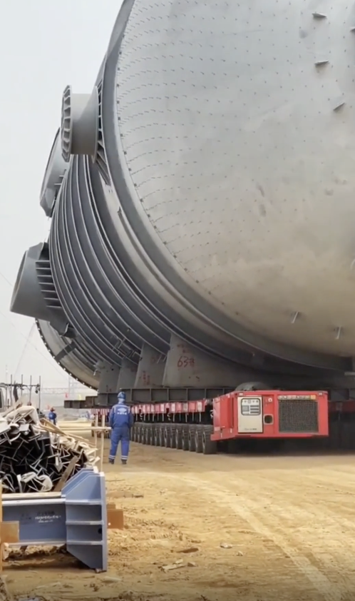 A huge tank towering over a man in a uniform