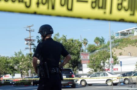 A police officer stands in a parking lot across the street from a Trader Joe's store where a hostage situation unfolded in Los Angeles, California, Saturday July 21, 2018. REUTERS/Andrew Cullen