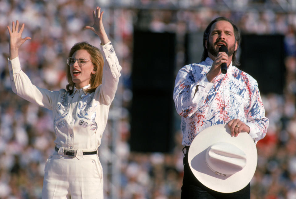 Garth Brooks, seen here with Marlee Matlin, performs the national anthem at Super Bowl XXVII on Jan. 31, 1993. He almost walked off less than an hour before showtime and ended up changing NFL policy on performances forever.<p>George Rose/Getty Images</p>