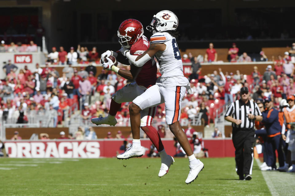 Arkansas defensive back Montaric Brown (21) intercepts a pass intended for Auburn receiver Ze'Vian Capers (80) during the first half of an NCAA college football game Saturday, Oct. 16, 2021, in Fayetteville, Ark. (AP Photo/Michael Woods)