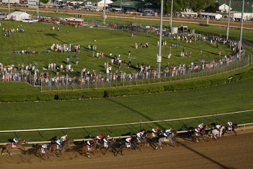 Medina Spirit, right, with John Velazquez aboard, leads the field around the first turn on the way to winning the 147th running of the Kentucky Derby at Churchill Downs, Saturday, May 1, 2021, in Louisville, Ky. (AP Photo/Charlie Riedel)