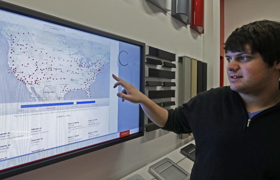 Tesla representative John Van Cleave displays a map showing present and planned supercharging stations located around the United States for Tesla's all electric car, Monday, March 17, 2014, at a Tesla showroom inside the Kenwood Towne Centre in Cincinnati. Ohio auto dealers are sparring at the Statehouse with the California-based Tesla, which is selling it's next generation electric cars from three Ohio storefronts. Lawmakers in Ohio and other states are trying to block Tesla direct sales on grounds they undercut traditional auto dealerships. (AP Photo/Al Behrman)