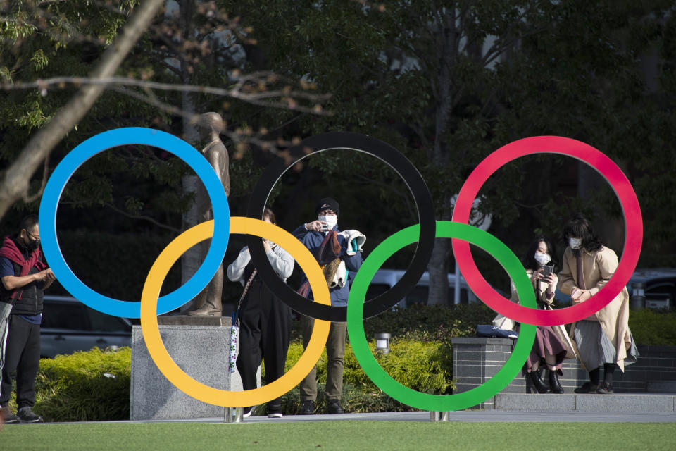 FILE - In this March 19, 2021, file photo, people take pictures of the Olympic rings installed by the Japan Olympic Museum in Tokyo. The vaccine rollout in Japan has been very slow with less than 1% vaccinated. This of course is spilling over to concerns about the postponed Tokyo Olympics that open in just over three months.(AP Photo/Hiro Komae, File)