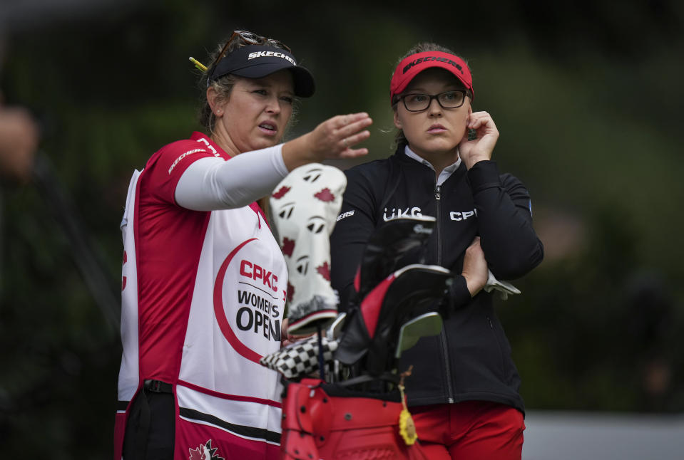 Brooke Henderson, right, of Canada, talks with her sister and caddie Brittany Henderson, left, before hitting her tee shot on the fourth hole during the second round at the LPGA CPKC Canadian Women's Open golf tournament in Vancouver, British Columbia, Friday, Aug. 25, 2023. (Darryl Dyck/The Canadian Press via AP)