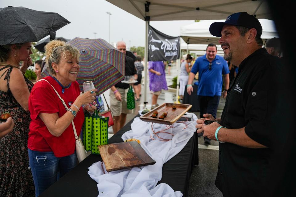 Two Guys catering hands out samples during the USA Today Wine and Food Experience at Paradise Coast Sports Complex in Naples on Saturday, Sept. 30, 2023.