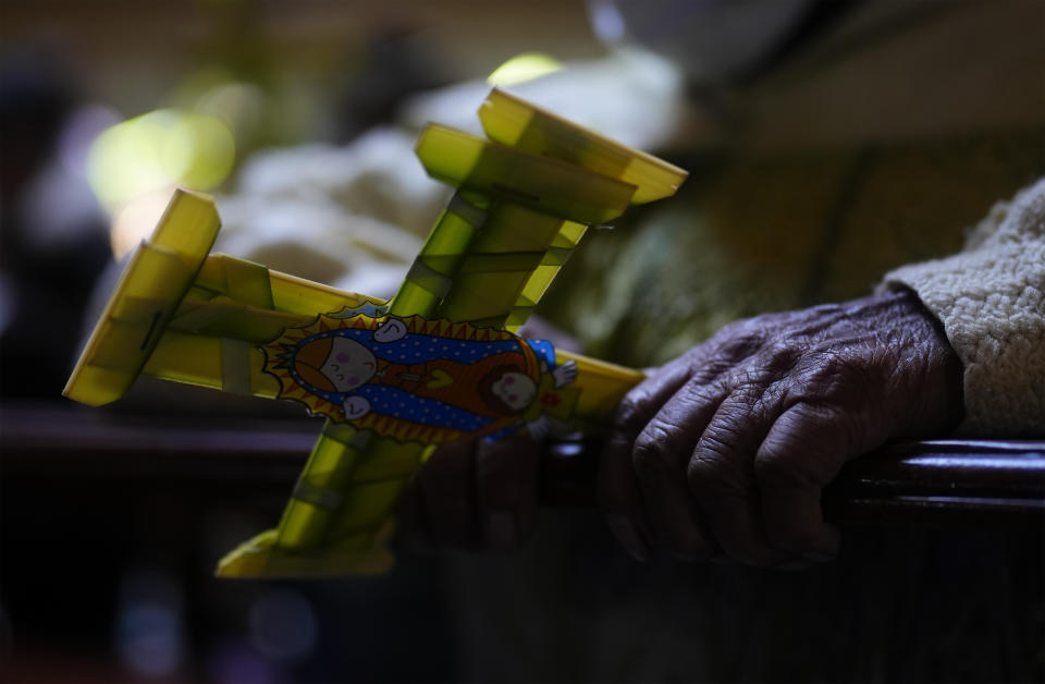 A woman holds up a palm frond in the shape of a cross during Palm Sunday Mass at a church in El Alto, Bolivia, Sunday, April 2, 2023. For Christians, Palm Sunday marks Jesus Christ's entrance into Jerusalem, when his followers laid palm branches in his path, prior to his crucifixion. (AP Photo/Juan Karita)