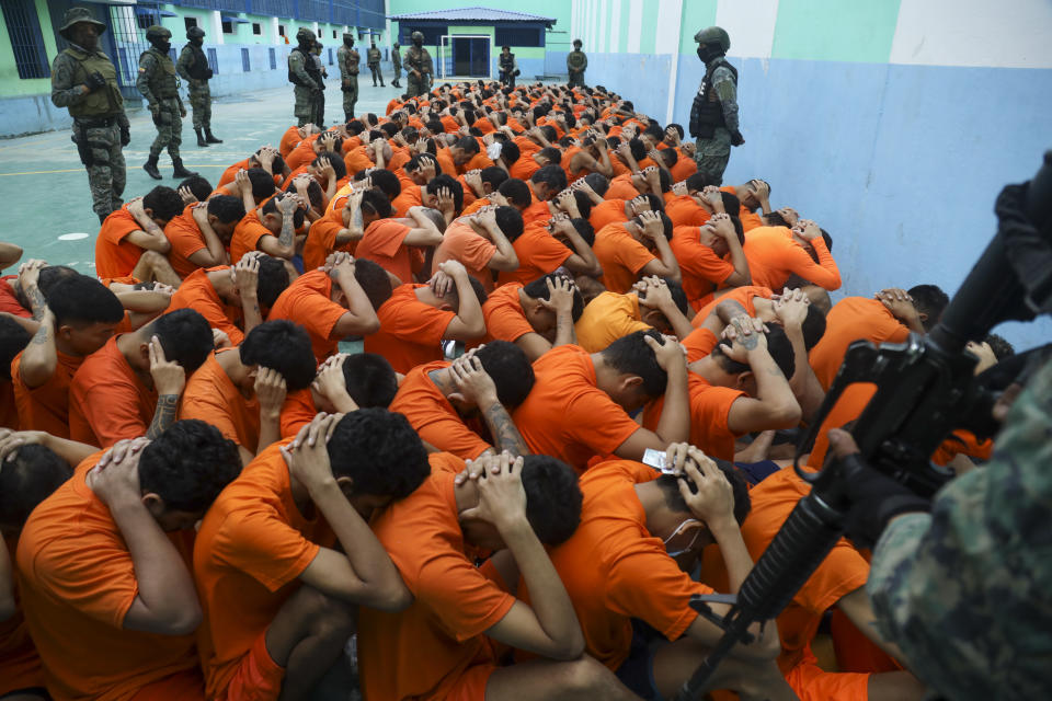 Inmates sit on the floor with their hands on their heads during a search by soldiers, at El Rodeo prison, in Portoviejo, Ecuador. Wednesday, June 5, 2024. Dozens of soldiers took control of the prison on Wednesday amid a spiral of murders, in the province of Manabí. (AP Photo/Cesar Munoz)