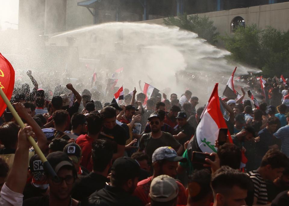 Iraqi security forces use a water cannon during a protest in Tahrir Square, in central Baghdad, Iraq, Tuesday, Oct. 1, 2019. Iraqi security forces fired tear gas on hundreds of protesters in the Iraqi capital who were demonstrating against corruption and bad public services. (AP Photo/Khalid Mohammed)