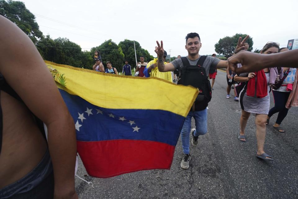 FILE - Migrants, many from Central American and Venezuela, walk along the Huehuetan highway in Chiapas state, Mexico, early June 7, 2022. The group left Tapachula on Monday, tired of waiting to normalize their status in a region with little work and still far from their ultimate goal of reaching the United States. About 6.8 million Venezuelans have left their homeland since an economic crisis took hold in earnest in 2014 for the country of some 28 million people. (AP Photo/Marco Ugarte, File)