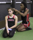 FILE - In this Feb. 7, 2019 file photo, Cromwell High School transgender athlete Andraya Yearwood, right, braids the hair of teammate Taylor Santos during a break at a track meet at Hillhouse High School in New Haven, Conn. Between 2017 and 2019, transgender sprinters Yearwood and Terry Miller combined to win 15 championship races, prompting a lawsuit on behalf of four cisgender girls. (AP Photo/Pat Eaton-Robb, File)