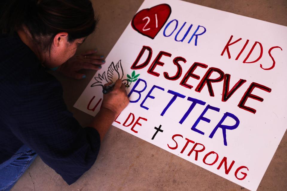 Pat Rivera, a teacher from Brownsville, Texas works on a sign at Jardin De Los Heroes Park in Uvalde. After the massacre, Republican lawmakers said they would focus heavily on improving mental health for Texas children, but Gov. Abbott's $105 million proposal for school safety this year allots just $10 million of that amount for mental health intervention.