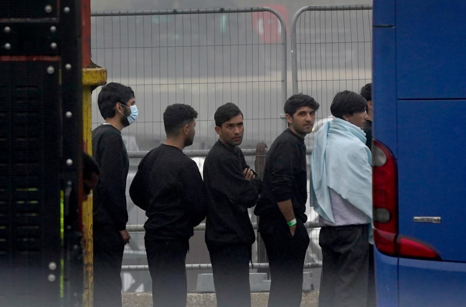 A group of people thought to be migrants board a bus.