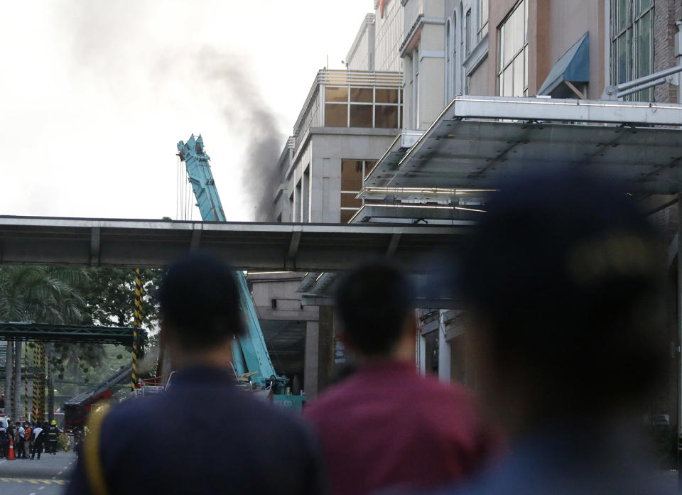 <p>Security watch as smoke comes out a hotel at the Resorts World Manila complex, early Friday, June 2, 2017, in Manila, Philippines. (Photo: Aaron Favila/AP) </p>