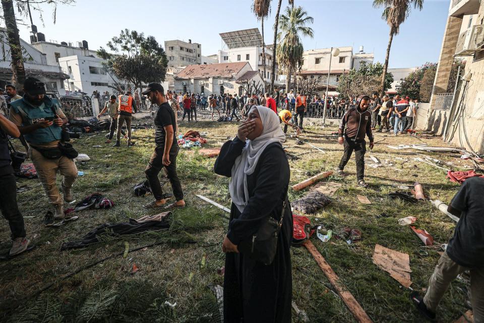 A Palestinian woman cries at the garden of al-Ahli Arab Hospital after it was hit with an explosion on Oct. 17, 2023. <a href="https://www.gettyimages.com/detail/news-photo/palestinian-woman-around-the-belongings-of-palestinians-news-photo/1730738212?adppopup=true" rel="nofollow noopener" target="_blank" data-ylk="slk:Mustafa Hassona/Anadolu via Getty Images;elm:context_link;itc:0;sec:content-canvas" class="link ">Mustafa Hassona/Anadolu via Getty Images</a>