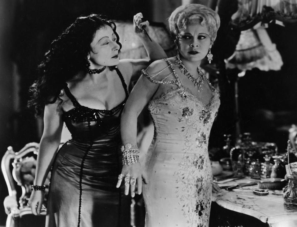 <p>Both onscreen and off, Mae West was typically found dripping in diamonds. So what makes her bejeweled getup in <em>She Done Him Wrong</em> so iconic? The famous actress actually purchased most of the jewelry in the film herself — from the chandelier diamond earrings to her wrist (and fist) full of gems. West would <a href="https://www.bejeweledmag.com/neil-lane-from-collecting-to-dressing-hollywood/" rel="nofollow noopener" target="_blank" data-ylk="slk:sell most of her jewelry;elm:context_link;itc:0;sec:content-canvas" class="link ">sell most of her jewelry</a> to donate to the war effort, but the 1920s 40-carat diamond bracelet worn in the 1933 film remained in her collection. The stunning piece was eventually purchased by jeweler Neil Lane. </p>