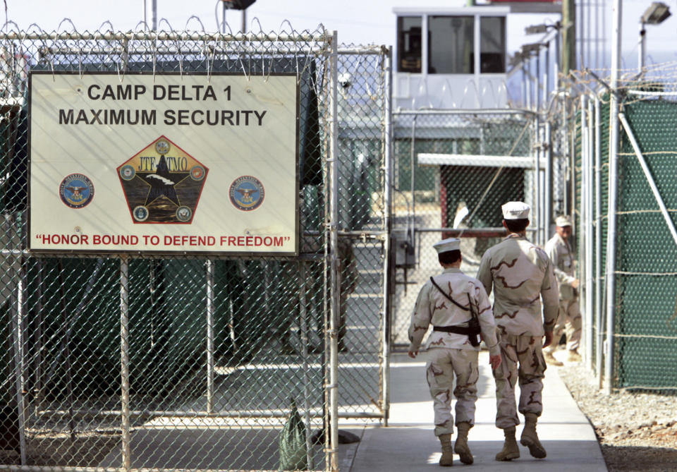 FILE - In this June 27, 2006 file photo, reviewed by a U.S. Department of Defense official, U.S. military guards walk within Camp Delta military-run prison, at the Guantanamo Bay U.S. Naval Base, Cuba. The White House says it intends to shutter the prison on the U.S. base in Cuba, which opened in January 2002 and where most of the 39 men still held have never been charged with a crime. (AP Photo/Brennan Linsley, File)