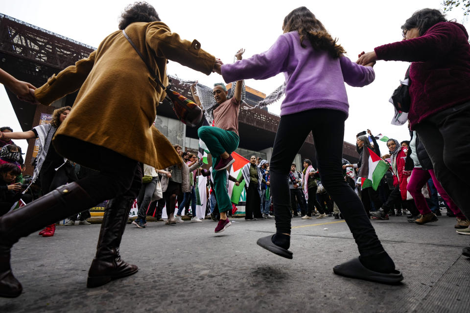 Manifestantes propalestinos bailan la danza folklórica dabke del Levante durante una protesta contra los ataques israelíes sobre Gaza, el 8 de junio de 2024, en Santiago, Chile. (AP Foto/Esteban Félix)