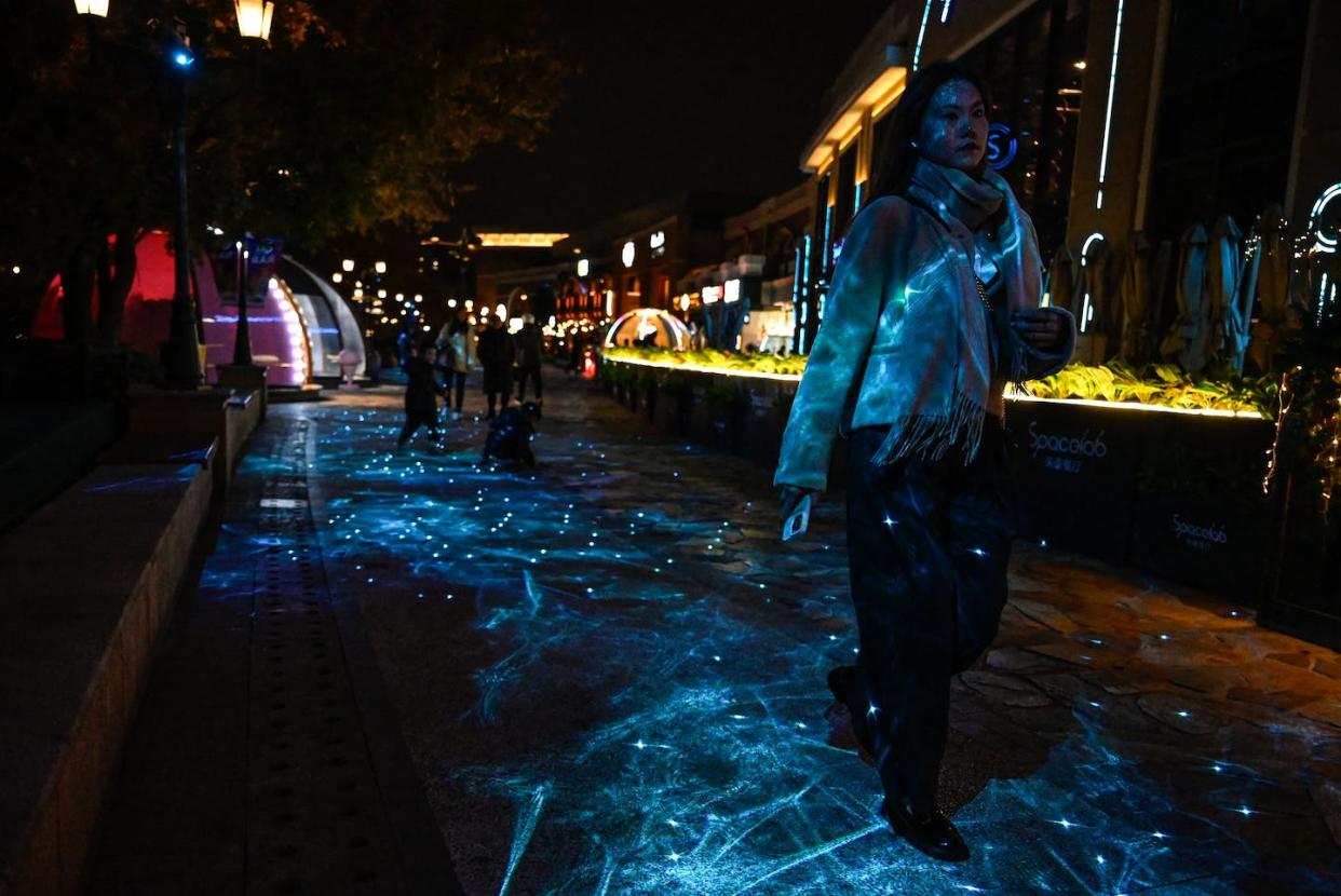 People walk under a light projection at a shopping mall in Beijing. <a href="https://www.gettyimages.com/detail/news-photo/people-walk-under-a-light-projection-at-a-shopping-mall-in-news-photo/1782952230" rel="nofollow noopener" target="_blank" data-ylk="slk:(Photo by Jade Gao / AFPJade Gao/AFP via Getty Images);elm:context_link;itc:0;sec:content-canvas" class="link ">(Photo by Jade Gao / AFPJade Gao/AFP via Getty Images)</a>