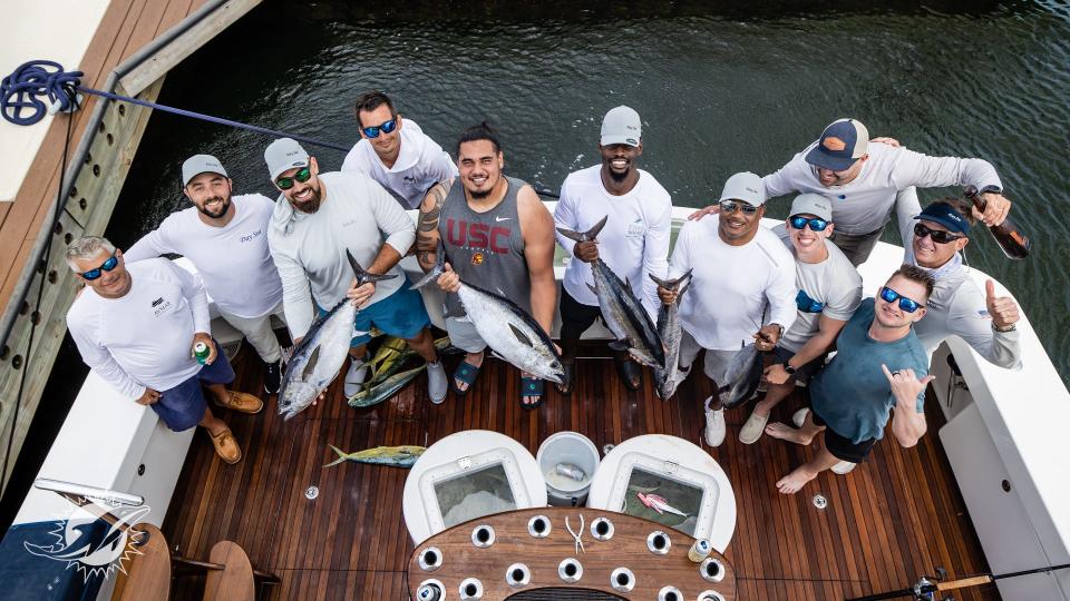 Dolphins players display their catch during Fins Weekend at the Grove Harbour Marina in Coconut Grove.