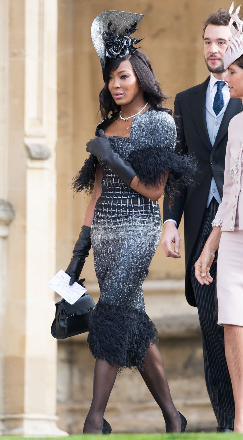 <p>Naomi Campbell's look at Princess Eugenie's wedding was flawless, including sleek leather gloves, a feather trim dress and gothic floral headpiece. </p>