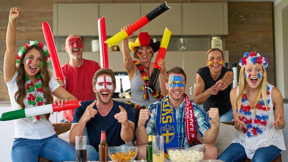 many happy international football fans are watching TV