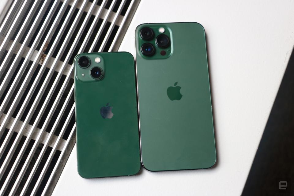 <p>A green iPhone 13 mini and an "Alpine green" iPhone 13 Pro Max on top of a surface with vents in the background.</p>
