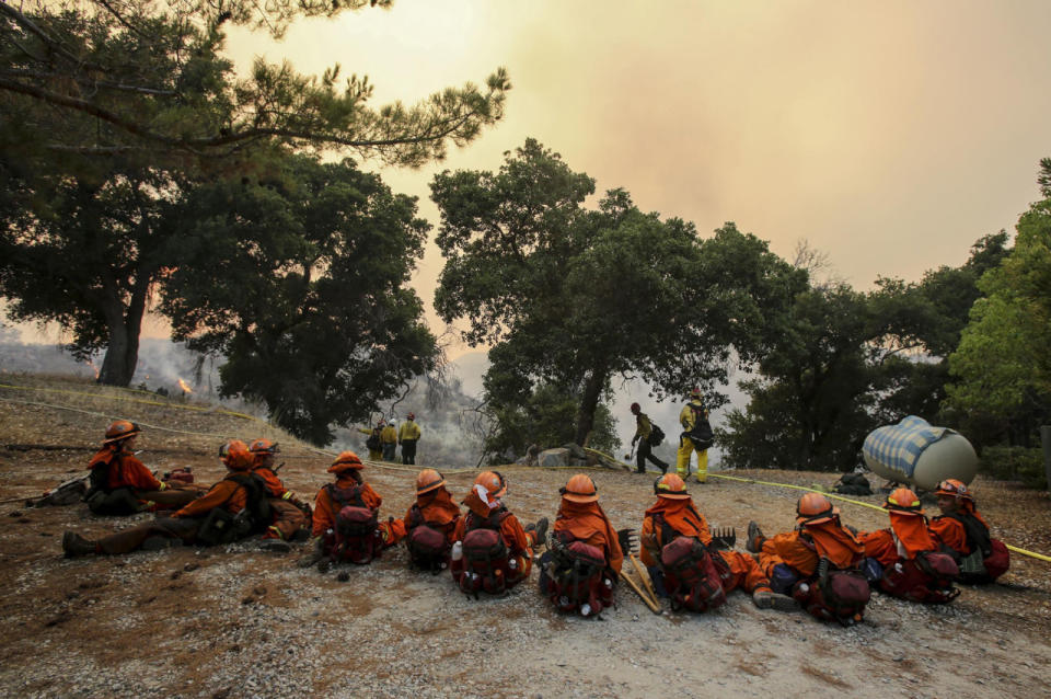 <p>Members of hand crew rest on a hillside near Placenta Canyon Road as a wildfire burns in Santa Clarita, Calif., July 24, 2016. (AP Photo/Ringo H.W. Chiu)</p>