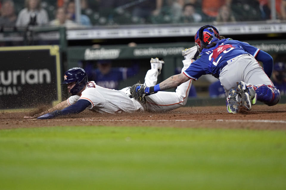 Houston Astros' Chas McCormick, left, is tagged out at home plate by Texas Rangers catcher Jose Trevino (23) during the 10th inning of a baseball game Thursday, May 13, 2021, in Houston. (AP Photo/David J. Phillip)