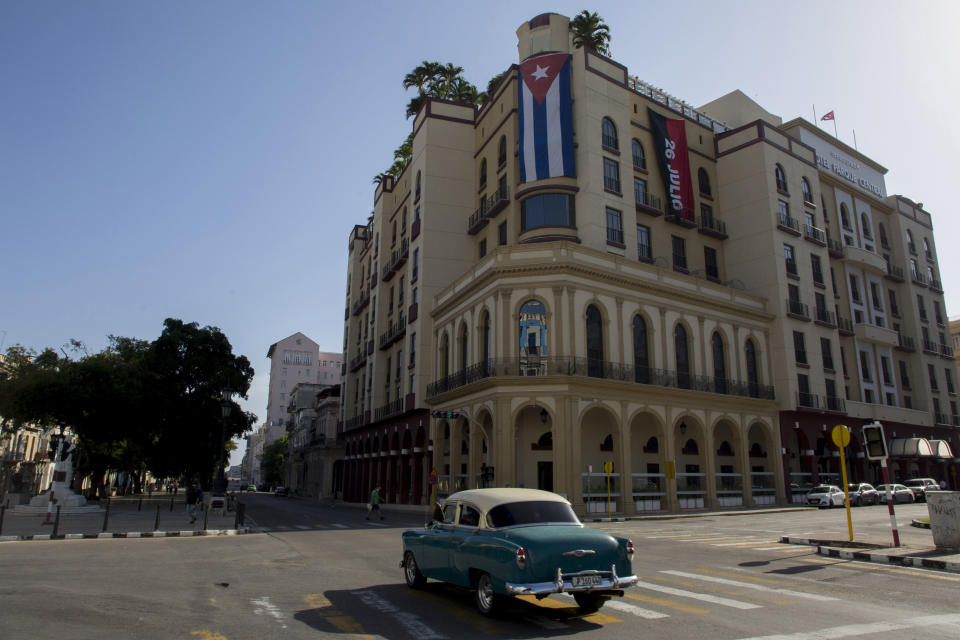 A Cuban flag hangs on Parque Central Hotel in Havana, Cuba, early Monday, July 12, 2021, the day after protests against food shortages and high prices amid the coronavirus crisis. (AP Photo/Ismael Francisco)