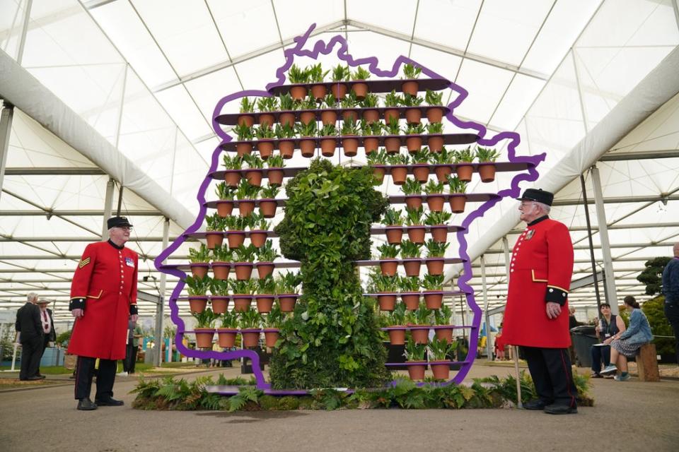 Chelsea Pensioners Ted Fell, left, and George Reid pose beside florist Simon Lycett’s The Queen’s Platinum Jubilee (Yui Mok/PA) (PA Wire)