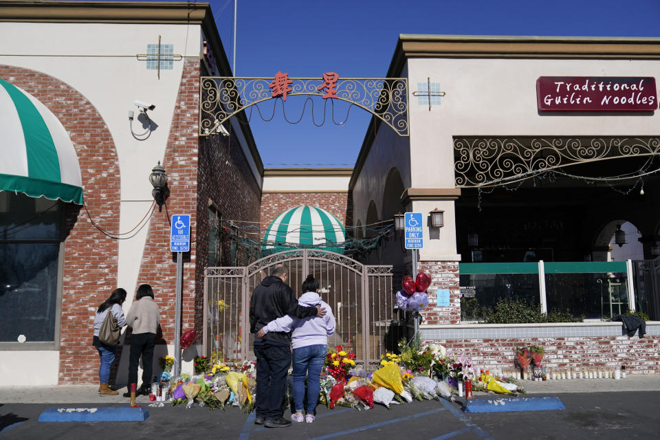 People stand near a memorial outside the Star Ballroom Dance Studio on Tuesday, Jan. 24, 2023, in Monterey Park, Calif. A gunman killed multiple people at the ballroom dance studio late Saturday amid Lunar New Years celebrations in the predominantly Asian American community. (AP Photo/Ashley Landis)