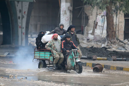 People ride a tricycle as they flee deeper into the remaining rebel-held areas of Aleppo, Syria December 7, 2016. REUTERS/Abdalrhman Ismail