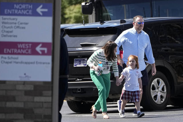 Adults walk with a child at a reunification center at the Woodmont Baptist Church after a shooting at The Covenant School, Monday, March 27, 2023, in Nashville, Tenn. (AP Photo/John Bazemore)