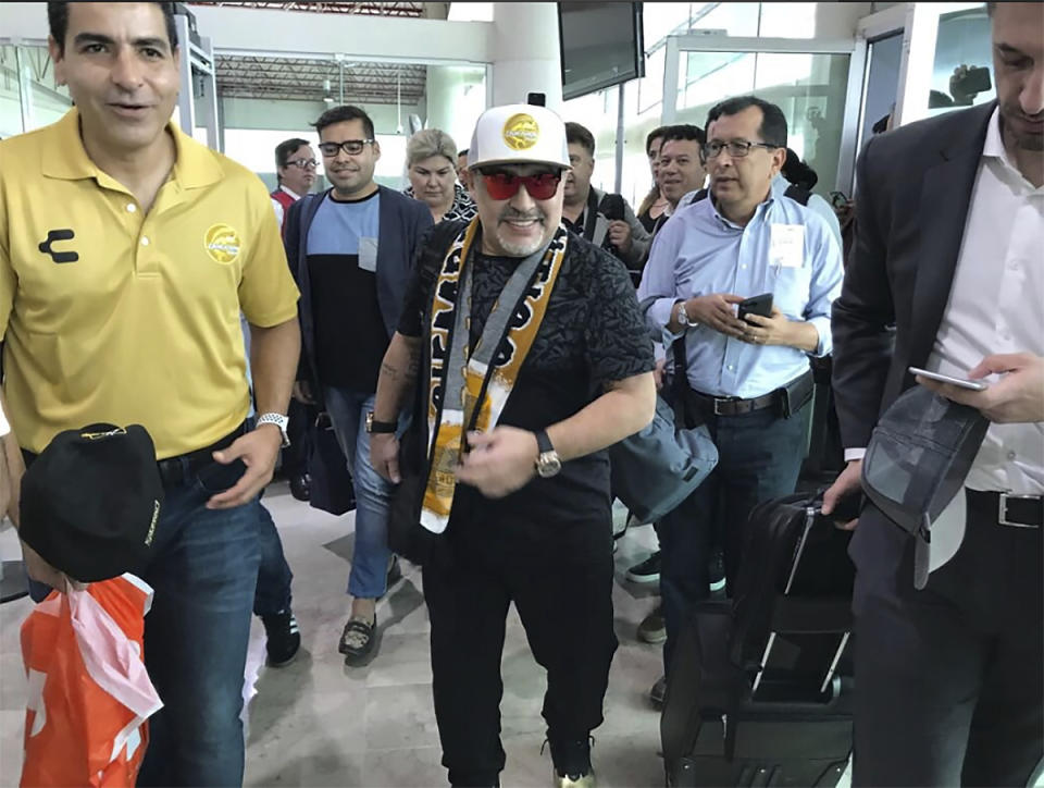 In this handout photo provided by Prensa Club Dorados de Sinaloa, Argentine soccer legend Diego Maradona walks through the airport in Culiacan, Mexico, Saturday, Sept. 8, 2018. Maradona arrived in northern Mexico Saturday afternoon, to begin his new job as head coach of the second-tier Mexican soccer club Dorados of Sinaloa. Pictured left is club president, Jose Antonio Nunez. (Prensa Club Dorados de Sinaloa via AP)