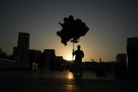 A balloon vender waits for customers at the Souq Waqif Market, in Doha, Qatar, Friday, Dec. 2, 2022. (AP Photo/Eugene Hoshiko)