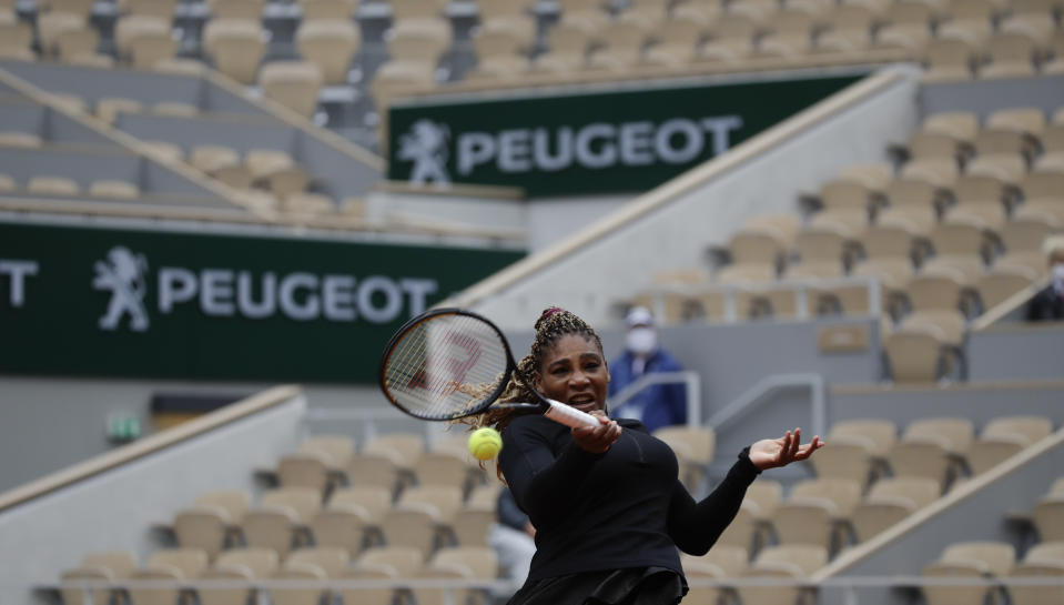Serena Williams devuelve ante Kristie Ahn en un casi desierto estadio Philippe Chatrier durante la primera ronda del Abierto de Francia, el lunes 28 de septiembre 2020, en París. (AP Foto/Alessandra Tarantino)
