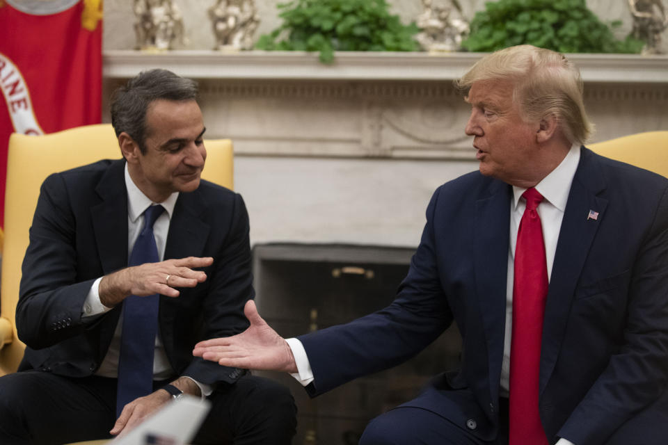 President Donald Trump, right, reaches to shake hands with Greek Prime Minister Kyriakos Mitsotakis during a meeting in the Oval Office of the White House, Tuesday, Jan. 7, 2020, in Washington. (AP Photo/Alex Brandon)